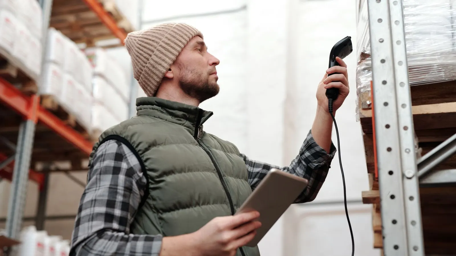 Opérateur scannant l'inventaire en entrepôt — données remontées dans l'ERP